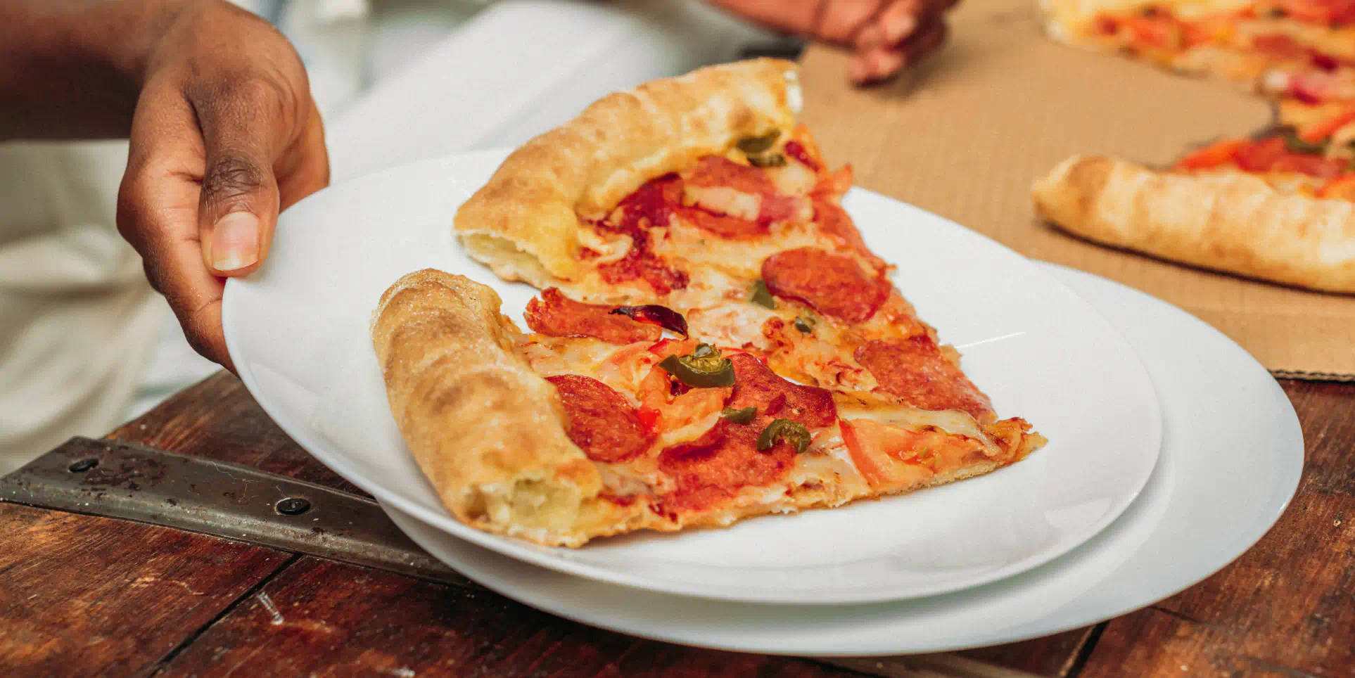 Person serving a slice of pizza